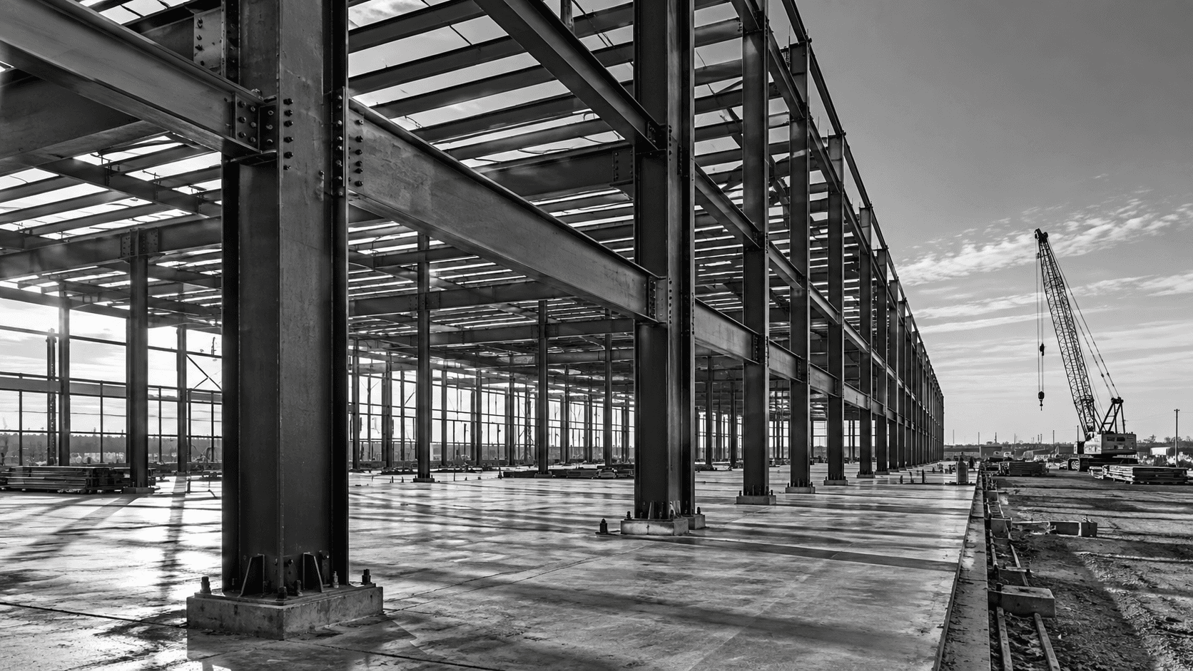 Illustrative black-and-white scene of a commercial steel-frame building under construction.